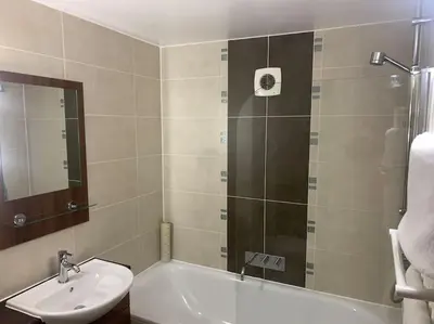 a bathroom with a shower and a sink and a tub at Ullswater Suite in Penrith