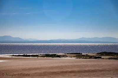 a beach with a large body of water at Arthur's Cottage in Dumfries