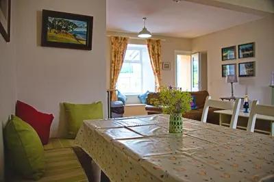 a living room with a table with a vase of flowers on it at Arthur's Cottage in Dumfries