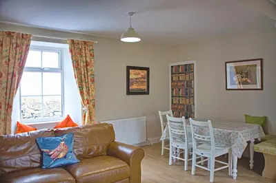 a living room with a couch and a table and chairs at Beachcombers in Dumfries