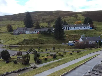 a village on a hill with a house and a road at 1-2 Dialknowe Holiday Cottage - Wanlockhead in Wanlockhead