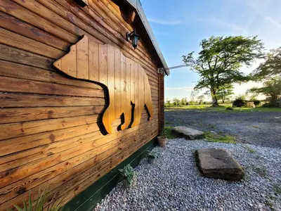 a wooden wall with a horse carved into it at Cosy wood cabin in rural area near national park in Cumnock