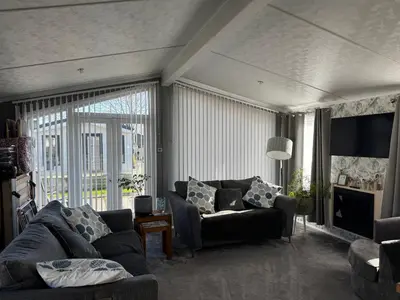 a living room with a couch and a table at A and C Lodge Plot 21 2 double bedrooms PLOT 21 With HOT TUB 1 pet only No Commercial Vans 4pm check in in High Hesket