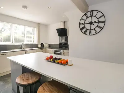 a kitchen with a counter with a clock on the wall at 26 Hycemoor Way in Millom