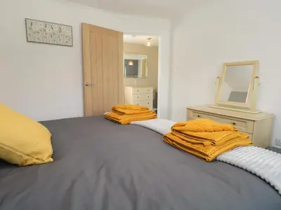 a bedroom with a bed with orange towels on it at 26 Hycemoor Way in Millom
