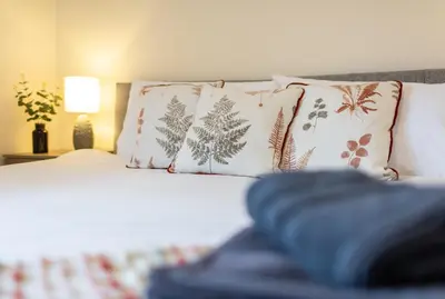 a bedroom with a bed with pillows and a bed sidx sidx sidx at Adrian House, near Hospital, easy parking + garden in Carlisle