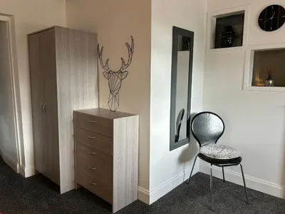 a bedroom with a dresser and a chair next to a cabinet at Solway Firth View in Annan