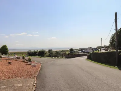 an empty road with a view of the ocean at Solway Cottage in Annan