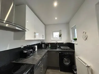a kitchen with a sink and a washing machine at Solway Cottage in Annan