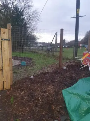 a fence with a playground in a park at Modernised 1720s cottage Newton Stewart Scotland in Newton Stewart