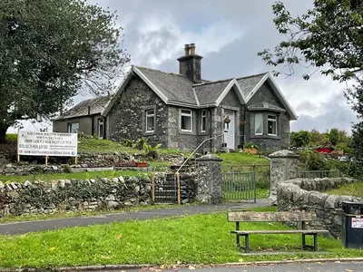 a stone house with a bench in front of it at Modernised 1720s cottage Newton Stewart Scotland in Newton Stewart