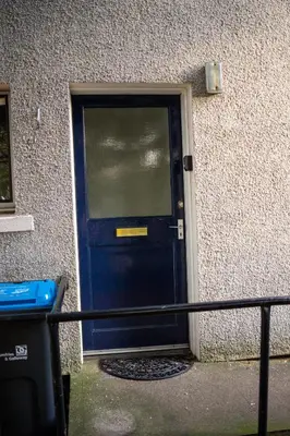 a blue door in the side of a building at Lovely self-catering apartment in city centre in Dumfries