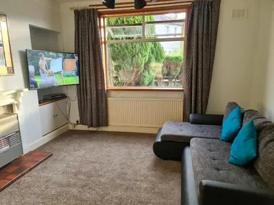 a living room with a couch and a large window at Lovely self-catering apartment in city centre in Dumfries