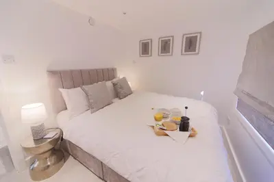 a white bed with a tray of food on it at The Hide in Carlisle