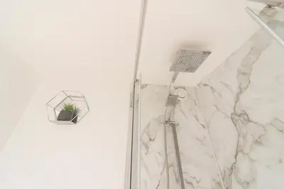 a shower with a shower head with a plant in it at The Hide in Carlisle