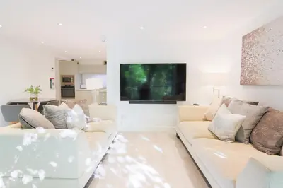 a living room with two white couches and a flat screen tv at The Hide in Carlisle