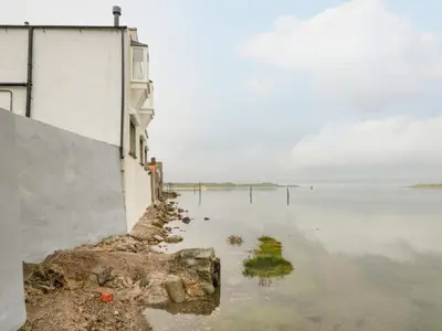a body of water next to a building at Waterside in Ravenglass
