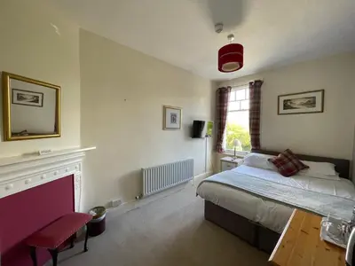 a bedroom with a bed and a fireplace at Ouse Bridge House in Bassenthwaite Lake
