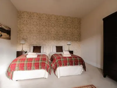 two twin beds in a bedroom with a wall at Cloud End in Keswick