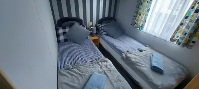 a small room with two beds in a room at Westmorland 32 caravan in Ballantrae