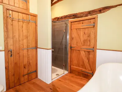 a bedroom with a shower and a wooden cabinet at Eagle Farmhouse in Glenridding