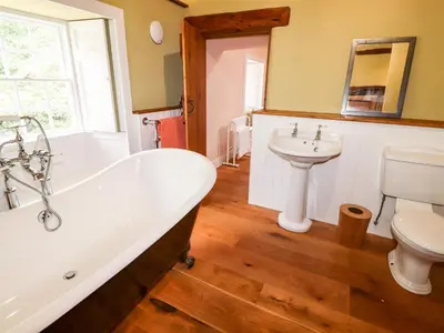 a bathroom with a tub and a toilet and a sink at Eagle Farmhouse in Glenridding