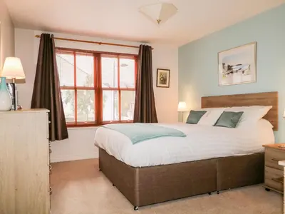 a bedroom with a bed and a large window at Derwent Haven in Keswick
