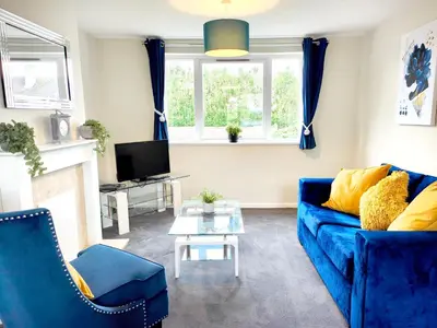 a living room with a blue couch and a tv at Terrance House, modern, spacious in Carlisle