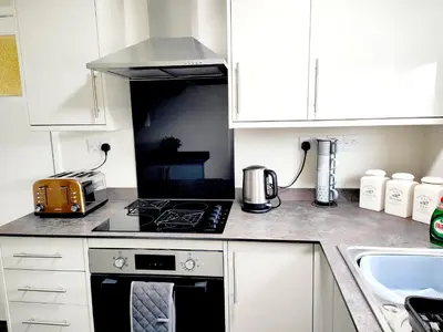 a kitchen with white cabinets and a stove top oven at Terrance House, modern, spacious in Carlisle
