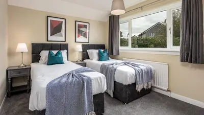 two beds in a room with a window at Leeward House - Donnini Apartments in Ayr