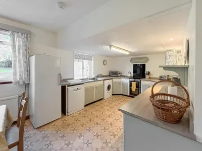 a kitchen with a white refrigerator and a counter at Woodend Farmhouse Halmyre in Haugh of Urr