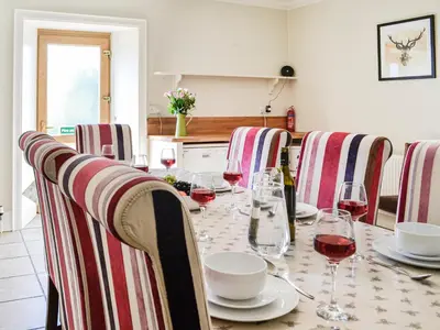 a dining room table with wine glasses on it at Repentance View in Carrutherstown