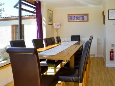 a dining room with a large wooden table and chairs at Kinvara in Stranraer