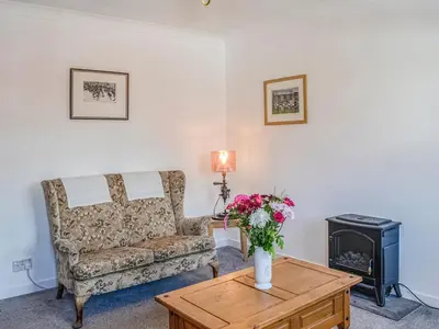 a living room with a couch and a wood stove at Ardencaple No 2 in Castle Douglas