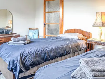 a bedroom with two beds and a mirror at Ardencaple No 2 in Castle Douglas