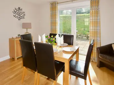 a dining room with a table and chairs at Arden Cottage in Twynholm