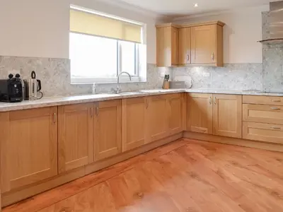 a kitchen with wooden cabinets and a window at Inverallan in Amisfield Town