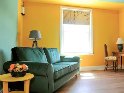 a living room with a green couch and a window at Holst Apartment in Newton Stewart