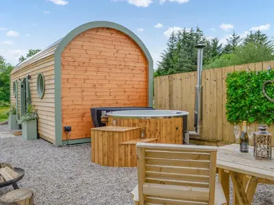 a backyard with a wooden shed with a table and chairs at Bracken - Uk34842 in Straiton