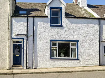 a white house with blue doors and windows at Hammy's Cottage in Drummore
