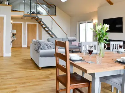 a dining room with a table and a couch at The Byre in Castle Douglas