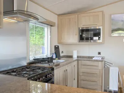a kitchen with a stove top oven next to a window at Tranquil Lodge - Uk35277 in Brigham