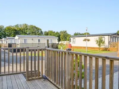 a wooden deck with a fence in front of a house at Tranquil Lodge - Uk35277 in Brigham