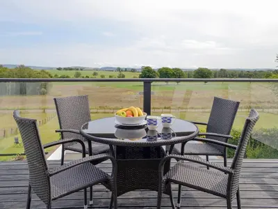 a table and chairs with a bowl of fruit on a balcony at Gin Case in Templand
