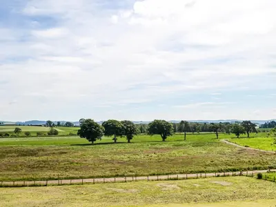 a field of grass with trees in the distance at Gin Case in Templand