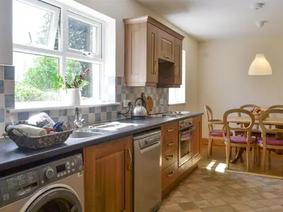 a kitchen with a sink and a dishwasher at Curlew Cottage in Dinwoodie Mains