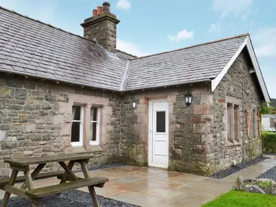 a stone building with a picnic table in front of it at Lealholme in Bassenthwaite