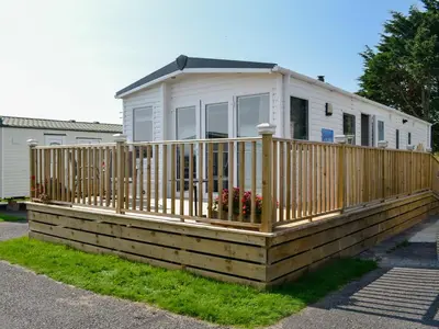 a mobile home with a wooden deck at Loch View in Kirkcolm