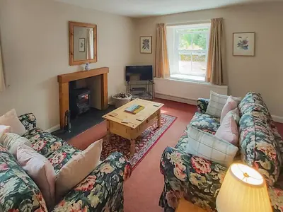 a living room with two couches and a table at Uk35716 - North Cottage in Teviothead