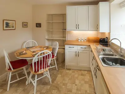 a kitchen with a table and chairs and a sink at Uk35716 - North Cottage in Teviothead